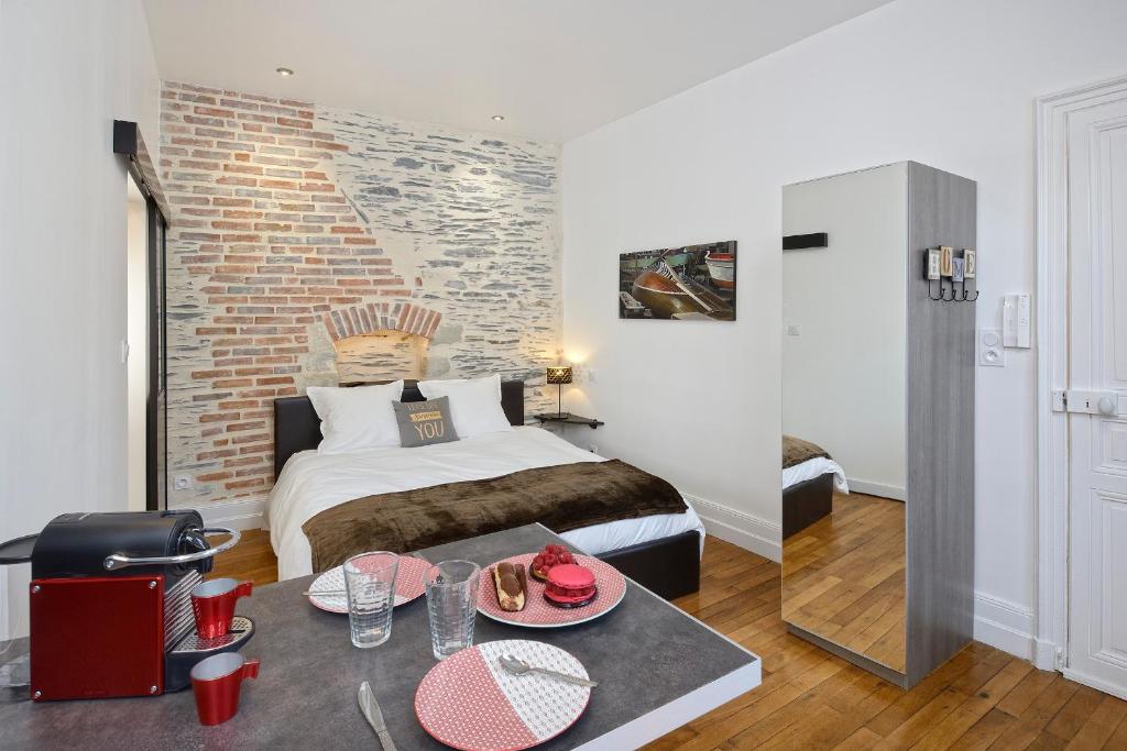 Un dormitorio con una cama y una mesa con comida. en Hyper Centre Rue Valdemaine, en Angers