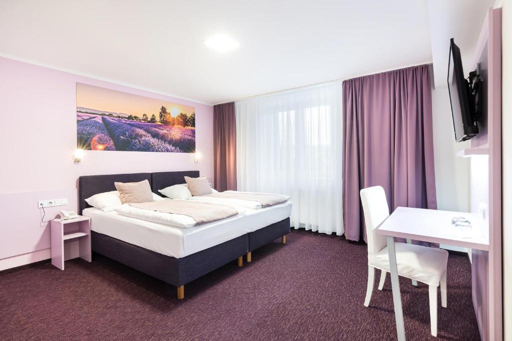 una camera d'albergo con letto e scrivania di Hotel Atlantis a Brno