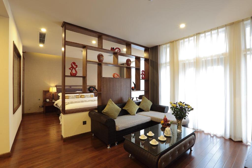 Sapa Legend Hotel & Spa في سابا: غرفة معيشة مع أريكة وطاولة