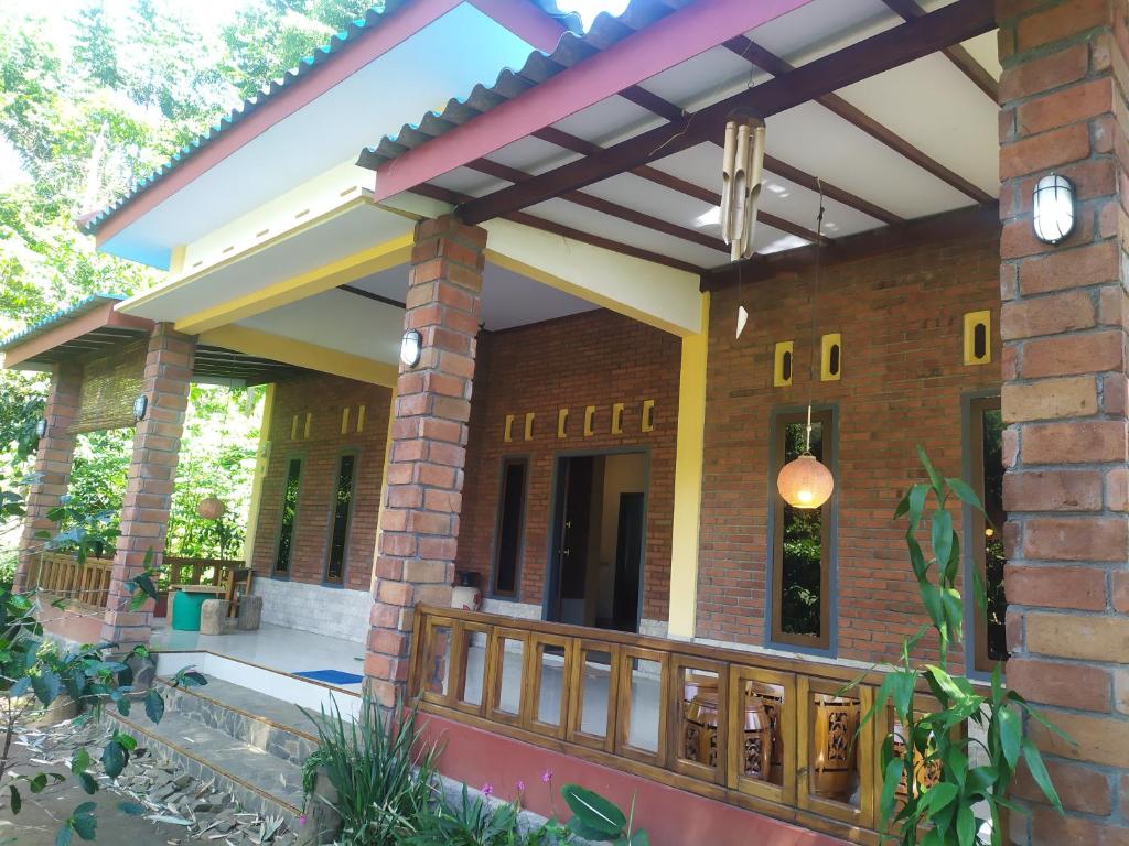 ceglany dom z drewnianym płotem przed nim w obiekcie KOPIKUIN bromo homestay w mieście Probolinggo