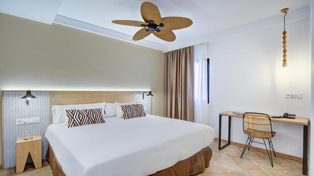 een hotelkamer met een groot bed en een bureau bij Arena Castillo in Caleta De Fuste