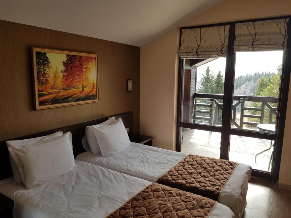 a bedroom with a bed and a large window at GOLDI 85 in Pamporovo