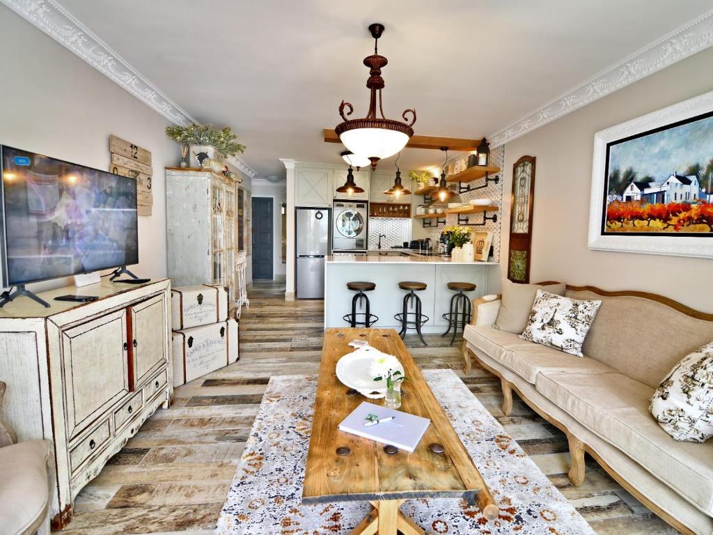 ein Wohnzimmer mit einem Sofa und einem Tisch in der Unterkunft dk villas 4 Riverview, Hout Bay in Hout Bay