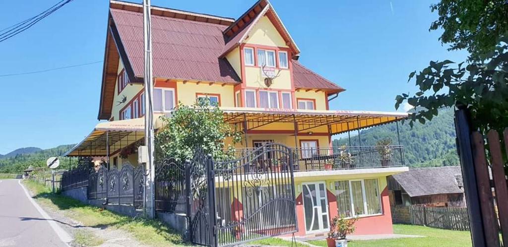a large house with a fence in front of it at Pensiunea Gaby in Dâmbovicioara