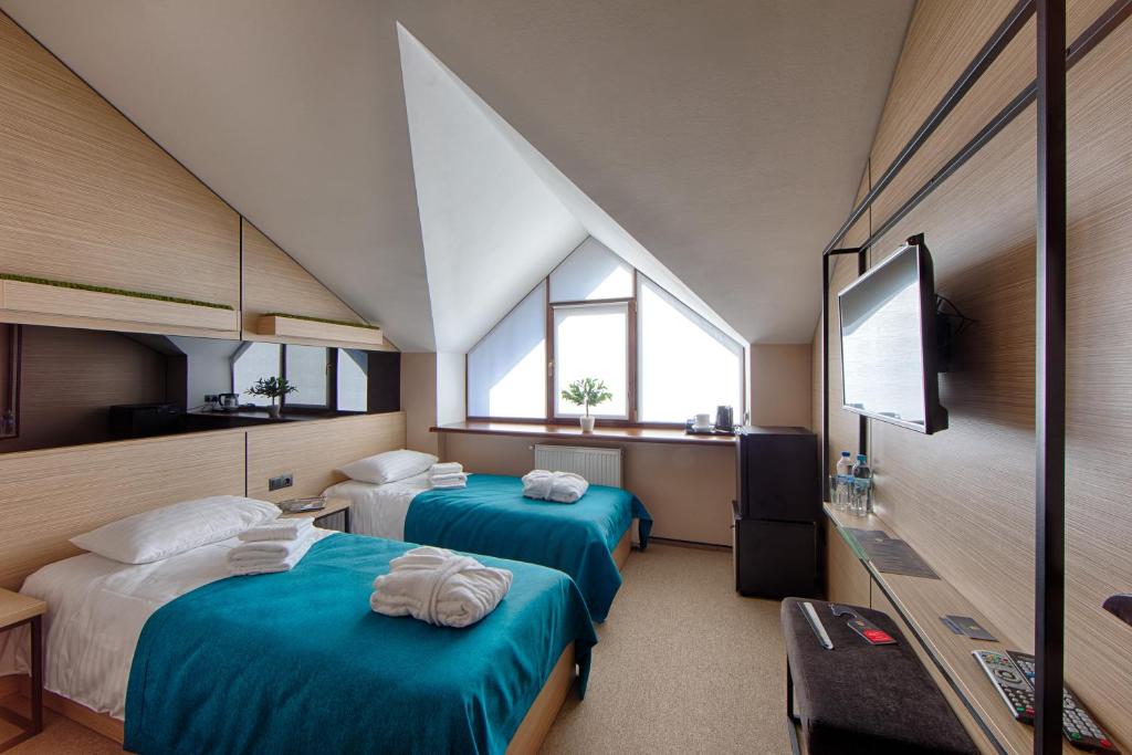 a hotel room with two beds and two windows at Hotel Riders Equides club in Lesniki