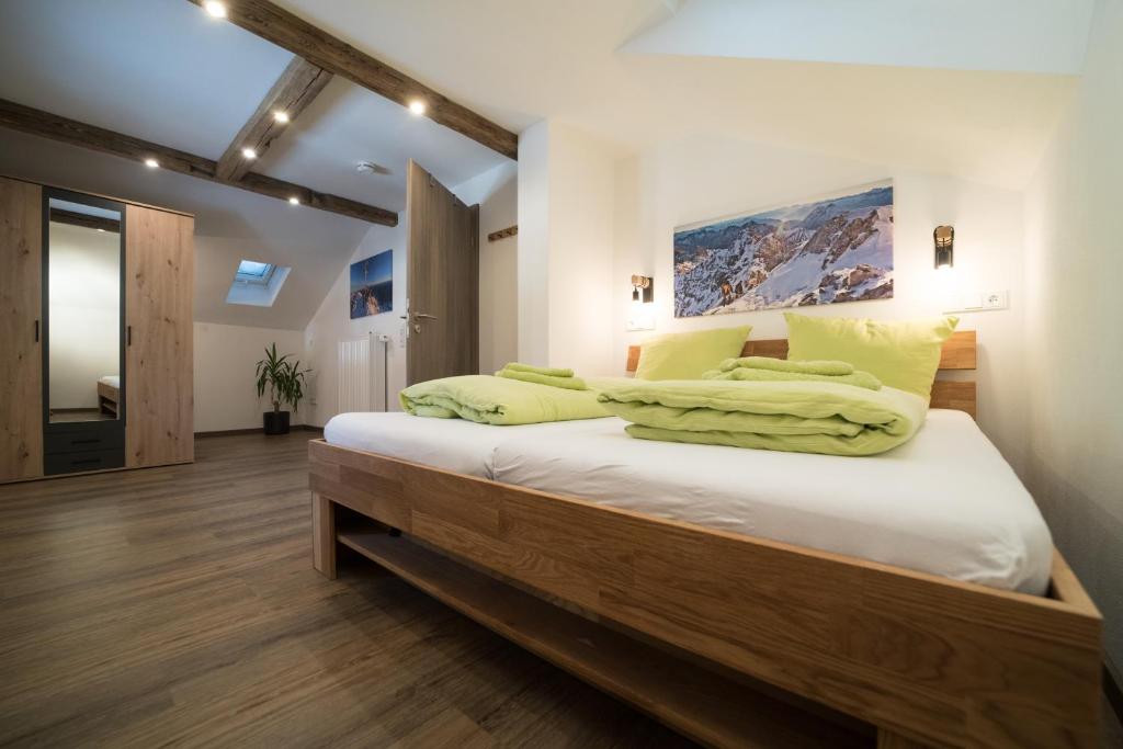 a bedroom with a large bed with white sheets and yellow pillows at Ferienwohnung Jubiläumsgrat in Grainau