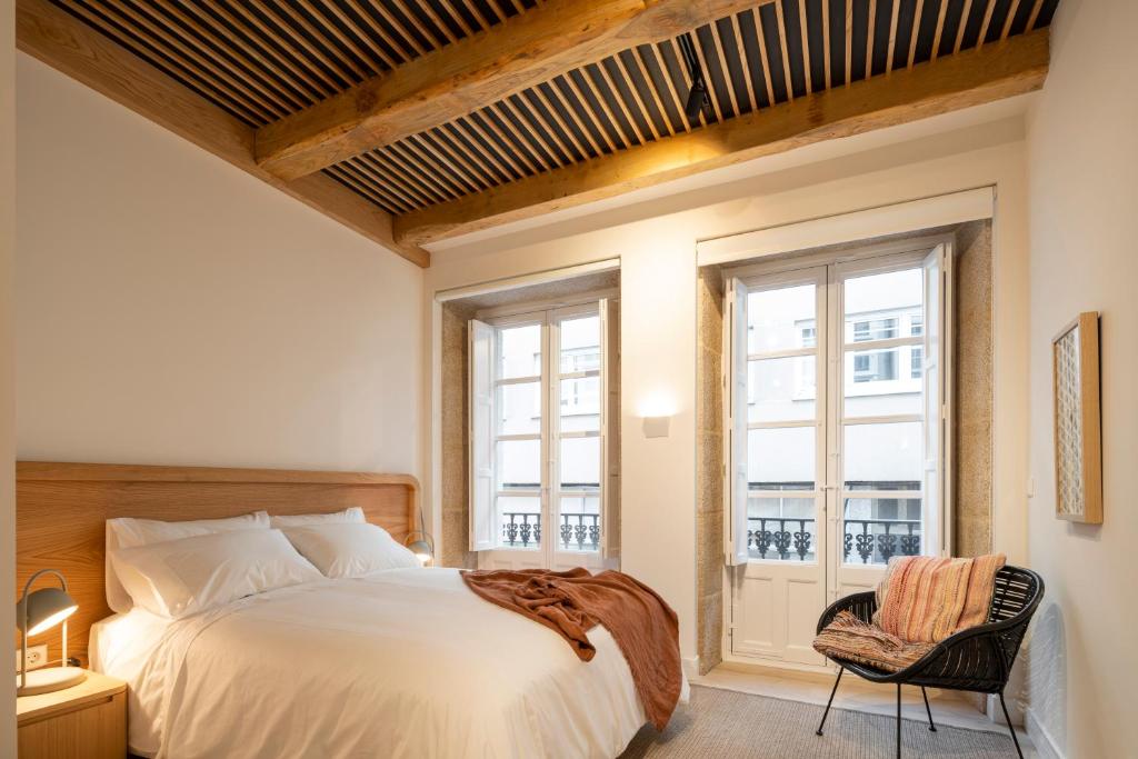 1 dormitorio con cama, ventana y silla en NORO Plaza, en A Coruña