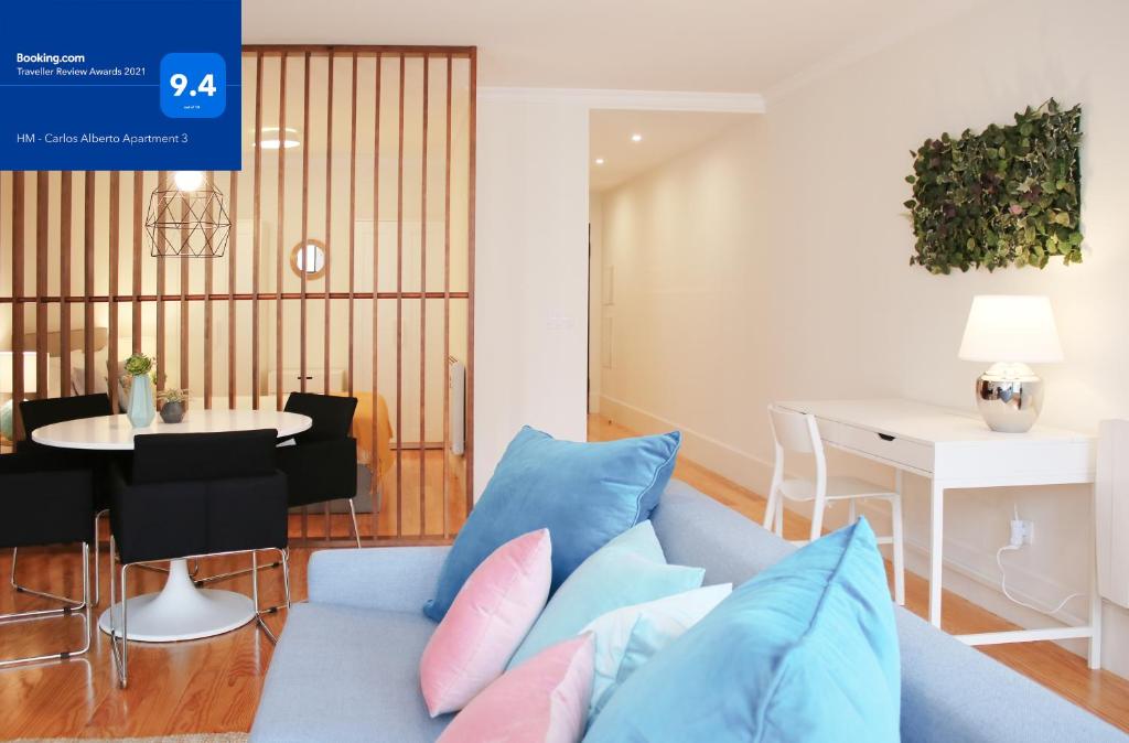 HM - Carlos Alberto Apartment 3 في بورتو: غرفة معيشة مع أريكة زرقاء وطاولة