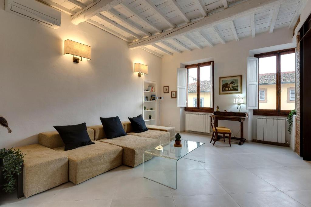 ein Wohnzimmer mit einem Sofa und einem Tisch in der Unterkunft Mamo Florence - Brancacci Suite in Florenz