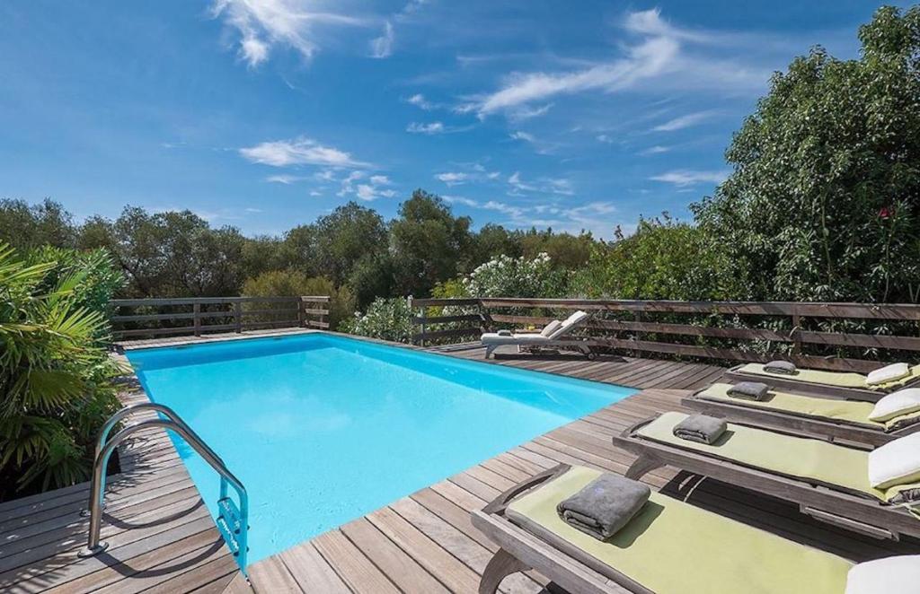 - une piscine sur une terrasse en bois avec des chaises longues dans l'établissement VILLA TORRACCIA 4 Étoiles, à Sainte-Lucie de Porto-Vecchio