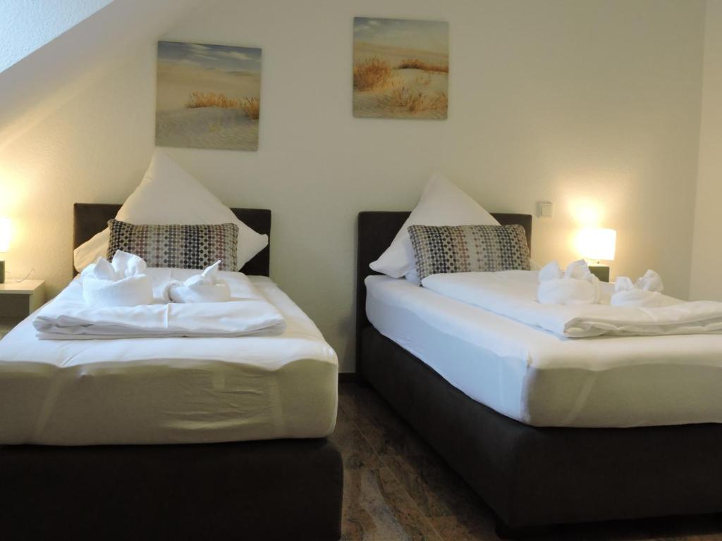una habitación con dos camas con sábanas blancas en Monteurhaus Scheidter 40, en Saarbrücken