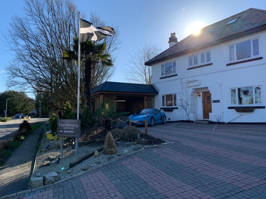 a white house with a flag in front of it at TRETHEWEY GUEST HOUSE in Fowey