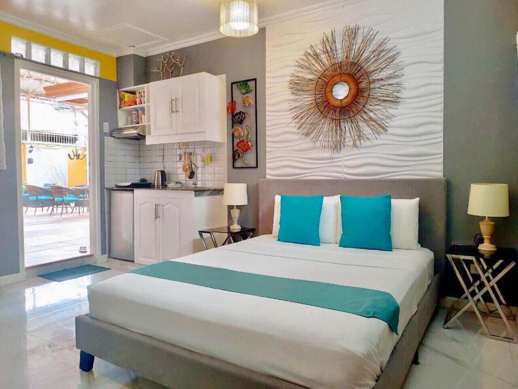 a bedroom with a bed and a dresser at Little Norway Guesthouse in Mactan