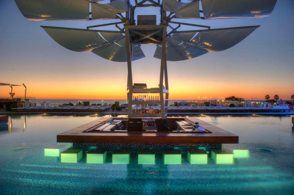 - une piscine avec un parasol dans l'eau dans l'établissement Veer Luxury Boutique Hotel & Beach Club, à Jounieh