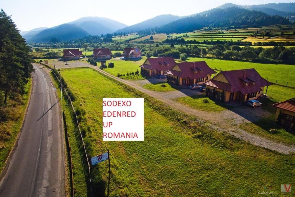 a sign in front of a house on a road at Pensiunea Sapte Flori in Gheorgheni