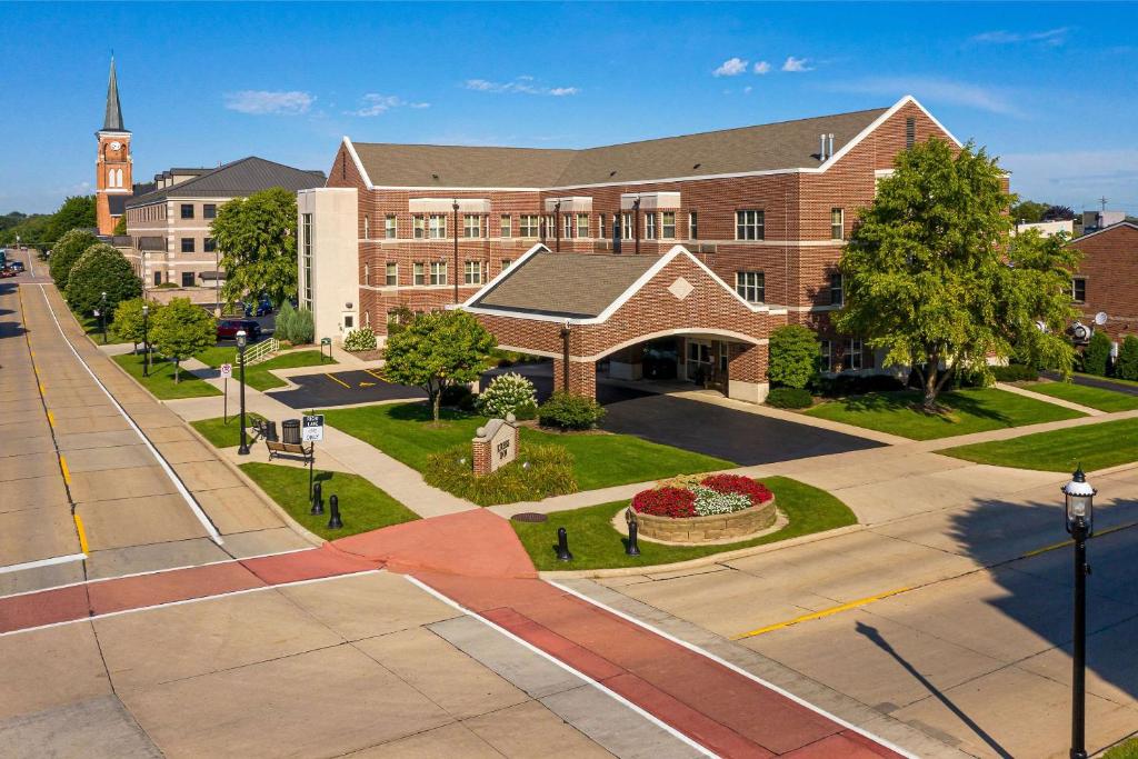 a large brick building with a church and a street at Kress Inn, Ascend Hotel Collection in De Pere