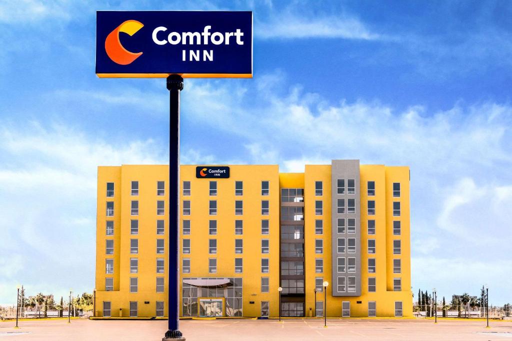 デリシアスにあるComfort Inn Deliciasの黄色い建物前のホテル看板