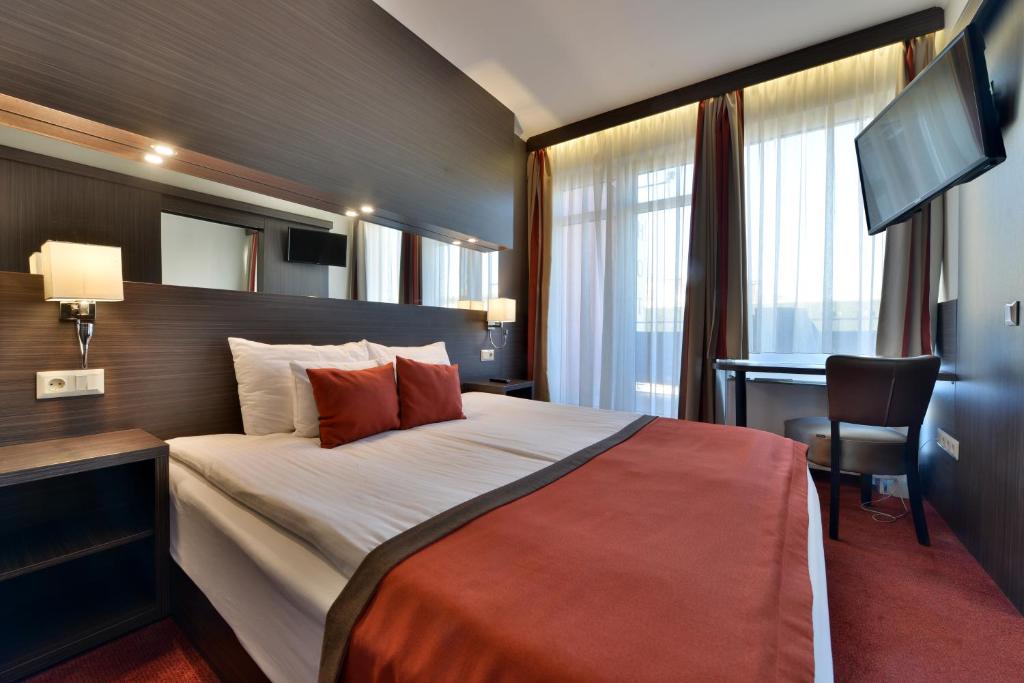 um quarto de hotel com uma cama grande e uma secretária em Hotel City Inn em Budapeste