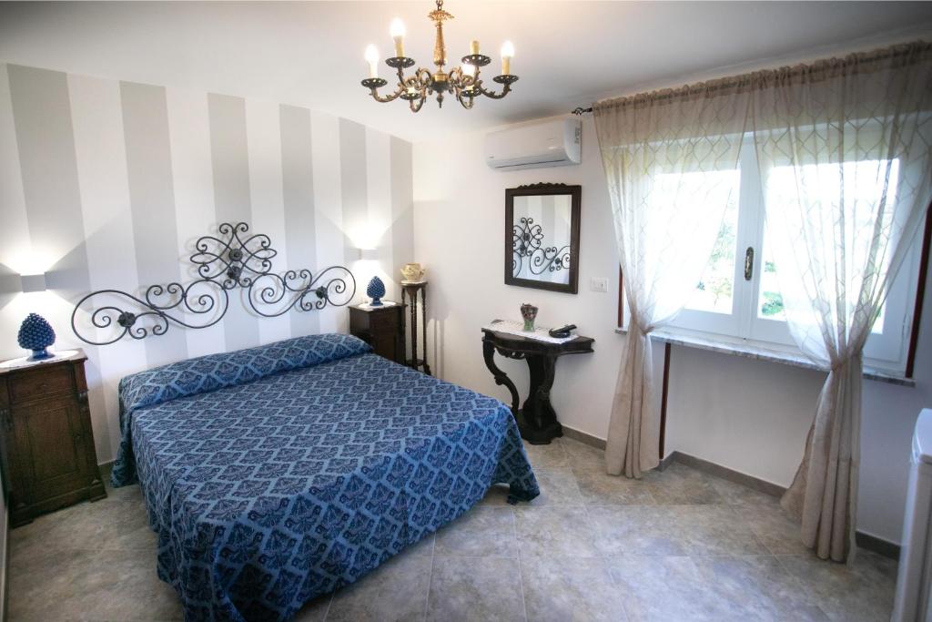 sypialnia z niebieskim łóżkiem i oknem w obiekcie Bed & Breakfast Elisabeth w Tropei