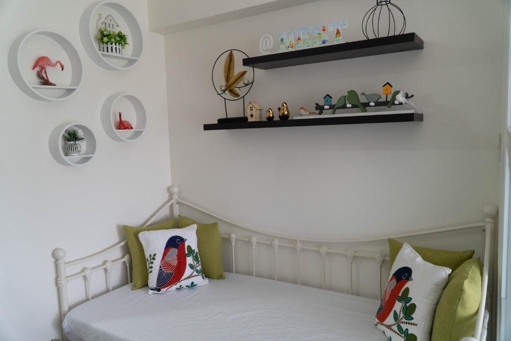 a bedroom with a bed with green and white pillows at An Oasis in Tagaytay in Tagaytay