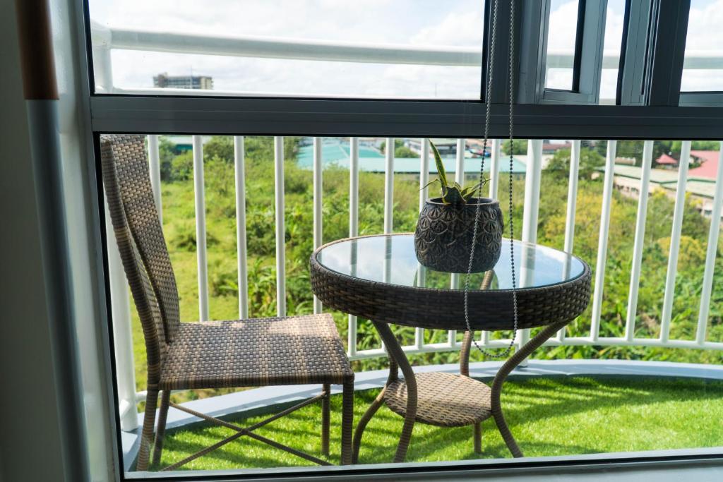 a glass table and two chairs on a balcony at An Oasis in Tagaytay in Tagaytay