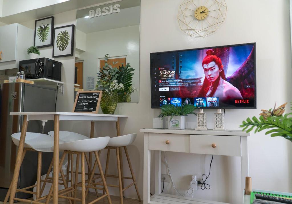 a waiting room with stools and a tv on the wall at An Oasis in Tagaytay in Tagaytay