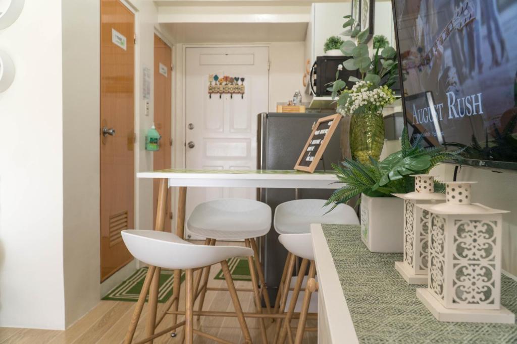a kitchen with white stools and a counter top at An Oasis in Tagaytay in Tagaytay