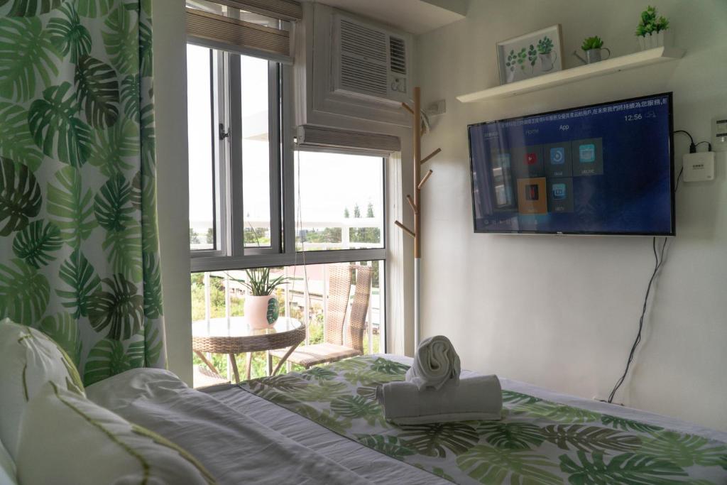 a bedroom with a bed and a large window at An Oasis in Tagaytay in Tagaytay