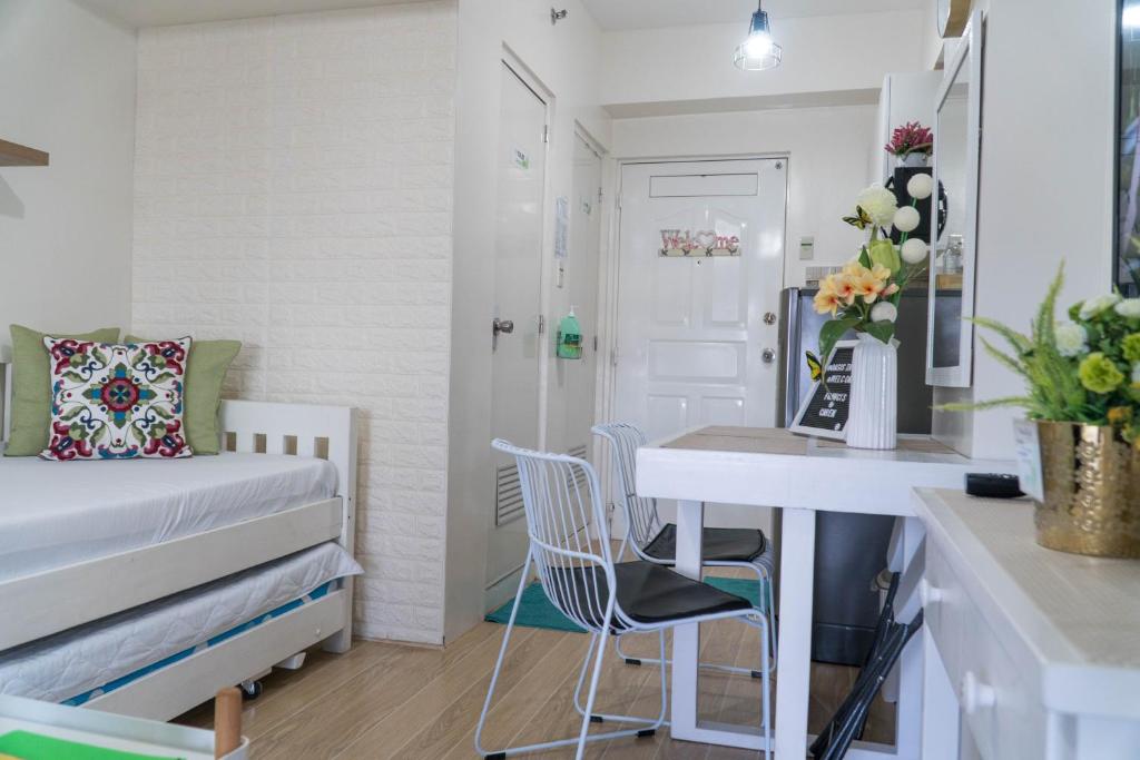 a small room with a bed and a desk with chairs at An Oasis in Tagaytay in Tagaytay