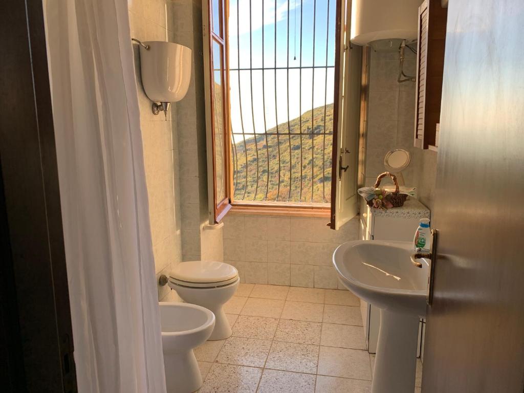 a bathroom with a toilet and a sink and a window at La dimora di Titiro in Cetraro