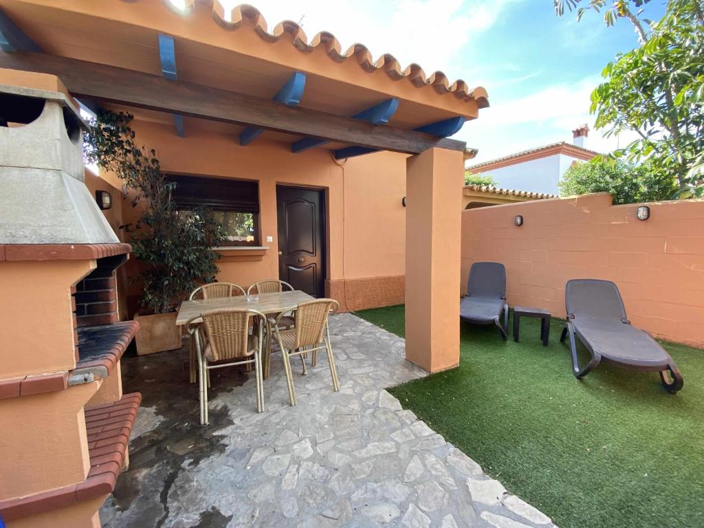 Un patio con mesa y sillas y una valla. en Casa Familiar cerca de la playa piscina compartida, en Cádiz