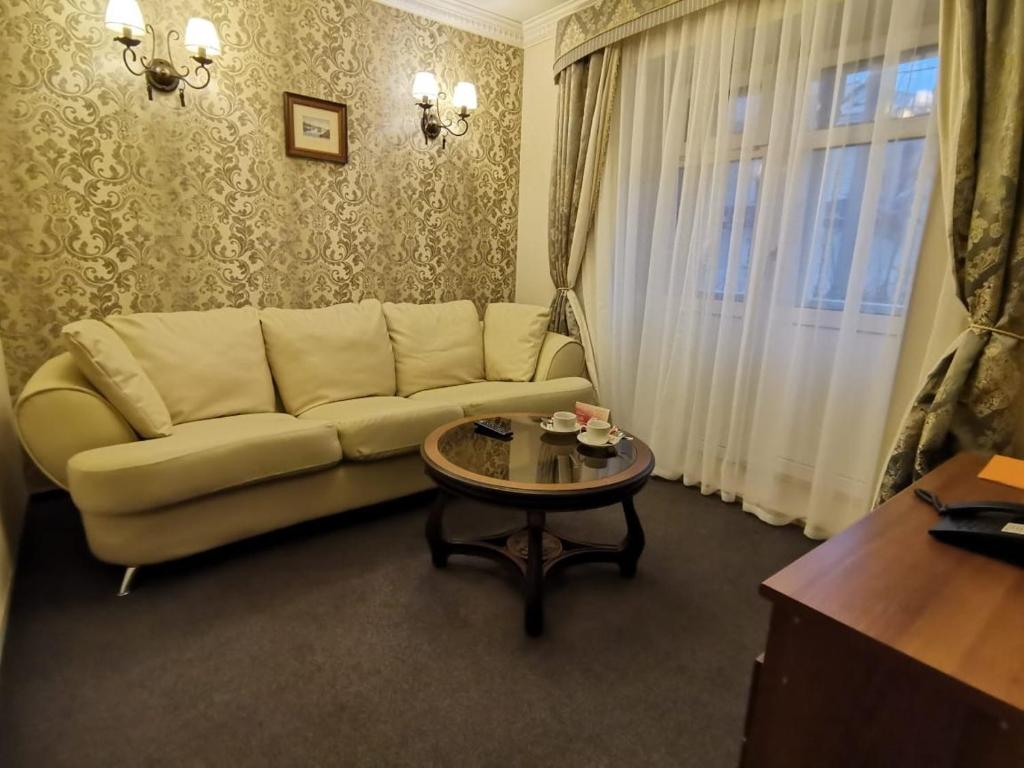 a living room with a couch and a table at History Hotel in Vologda