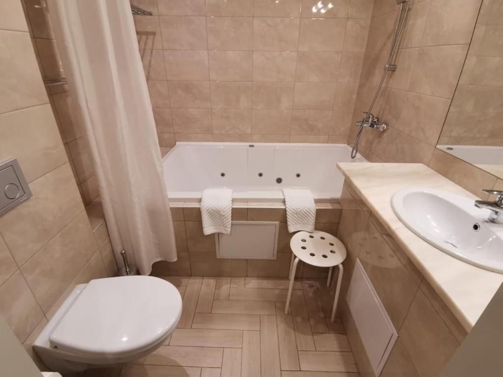 a bathroom with a tub and a toilet and a sink at History Hotel in Vologda