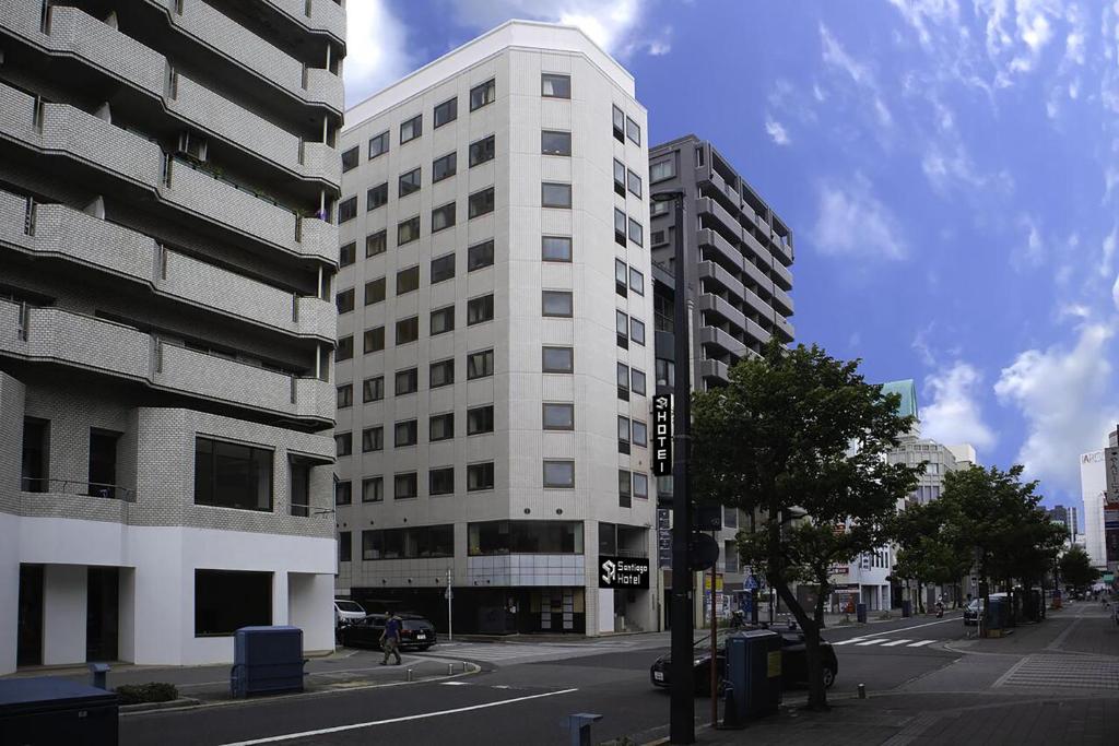 a tall white building on a city street at Santiago Hotel in Hiroshima