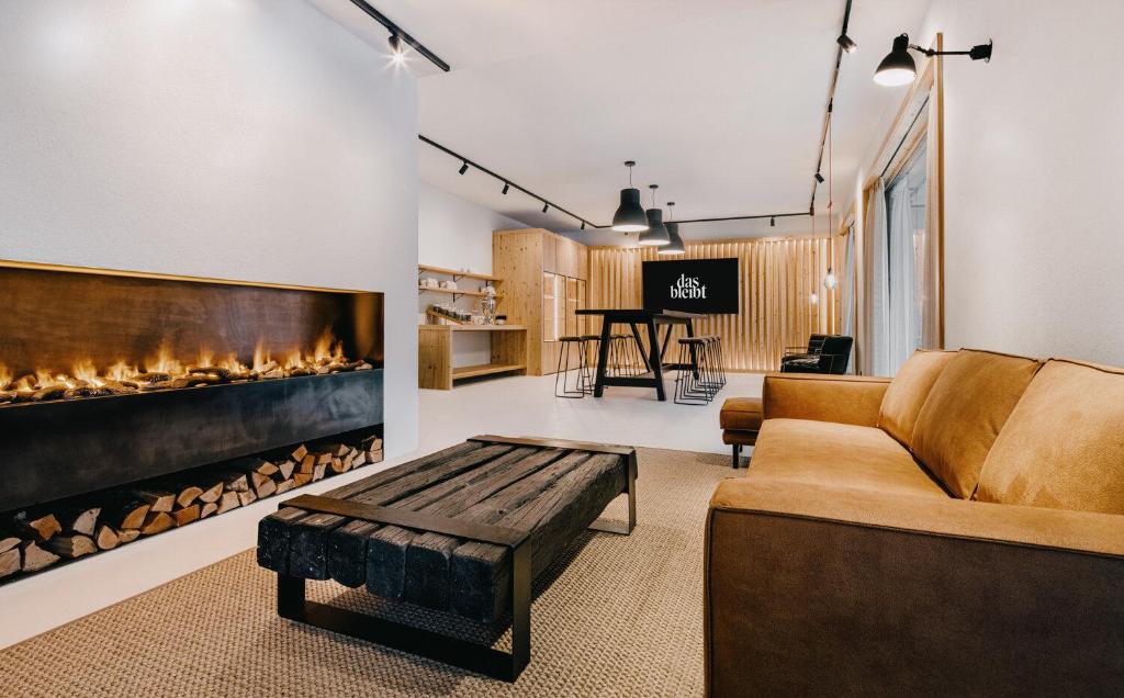salon z kanapą i kominkiem w obiekcie das bleibt Alpine Suites w Schladming