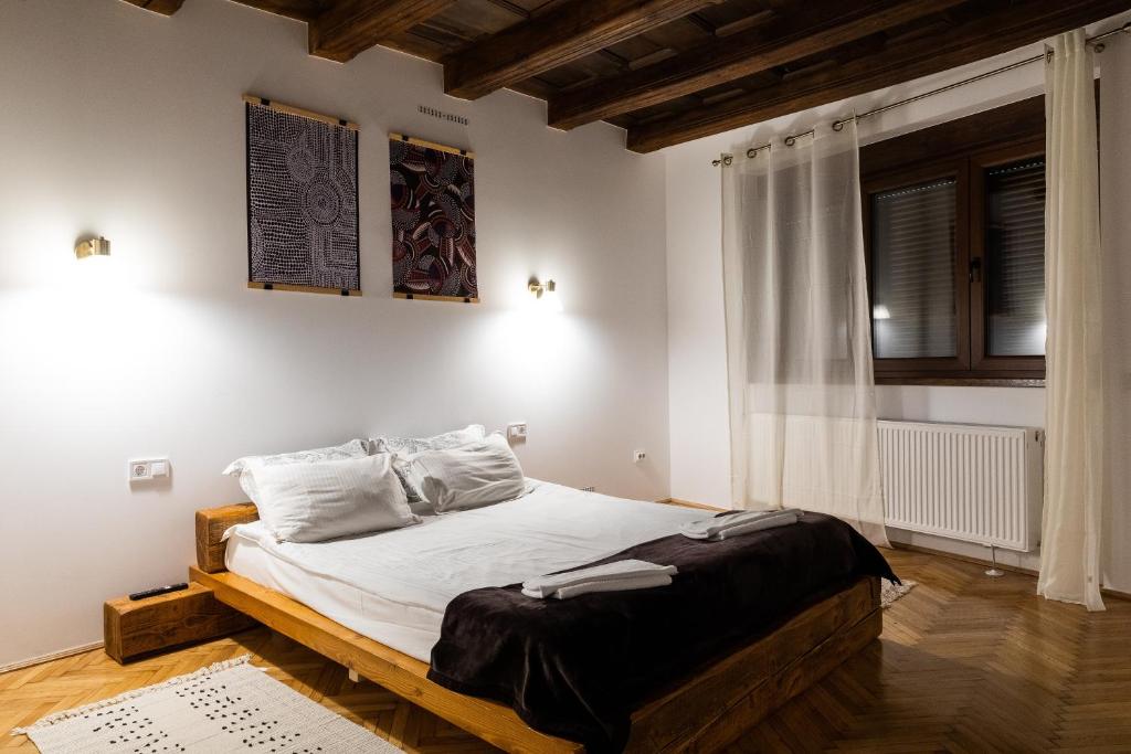 - une chambre avec un lit dans une pièce aux murs blancs dans l'établissement Casa Postavarului, à Braşov