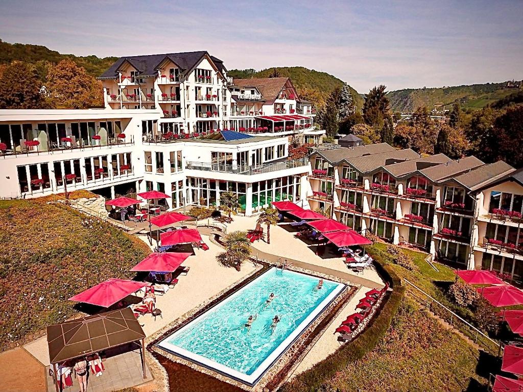 een luchtzicht op een resort met een zwembad en parasols bij Moselstern Parkhotel Krähennest in Löf