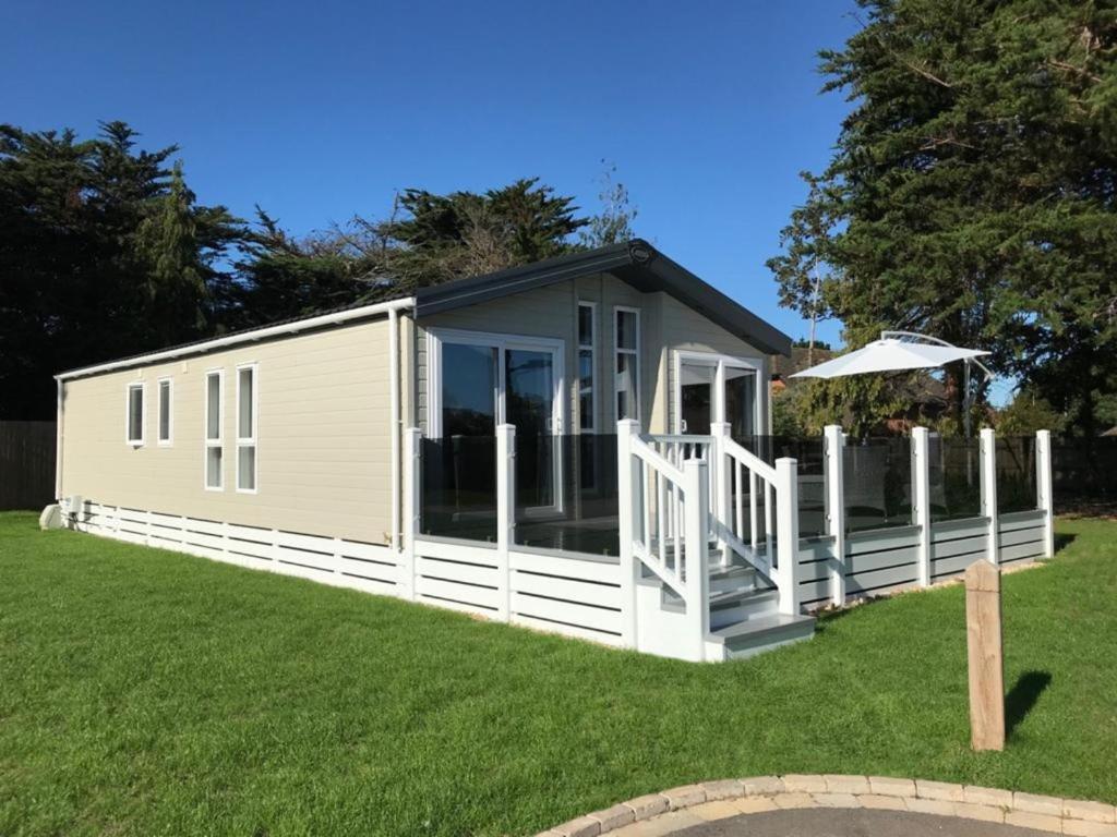 a tiny house with a porch and a deck at 6 berth luxury lodge in Christchurch Dorset in Christchurch