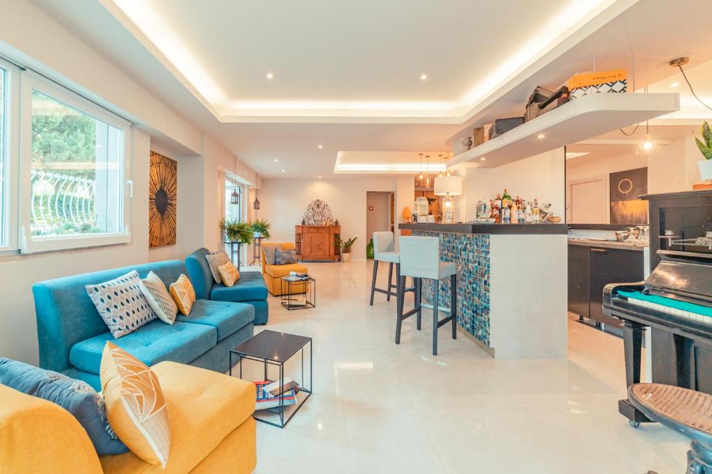 a living room with a blue couch and a kitchen at Hotel Rivage Taormina in Taormina