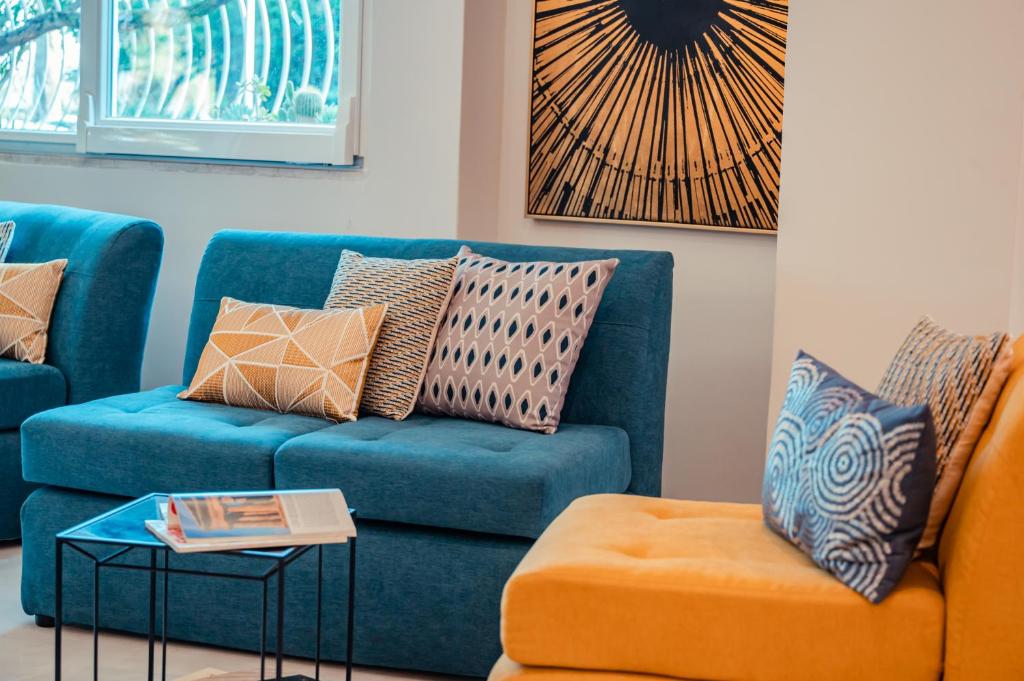 a living room with a blue couch and an orange chair at Hotel Rivage Taormina in Taormina