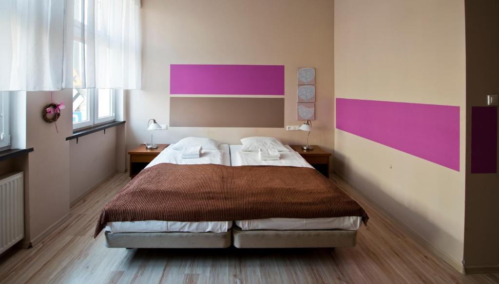 1 dormitorio con 1 cama con paredes de color púrpura y rosa en Apartamenty Parkowe, en Bydgoszcz