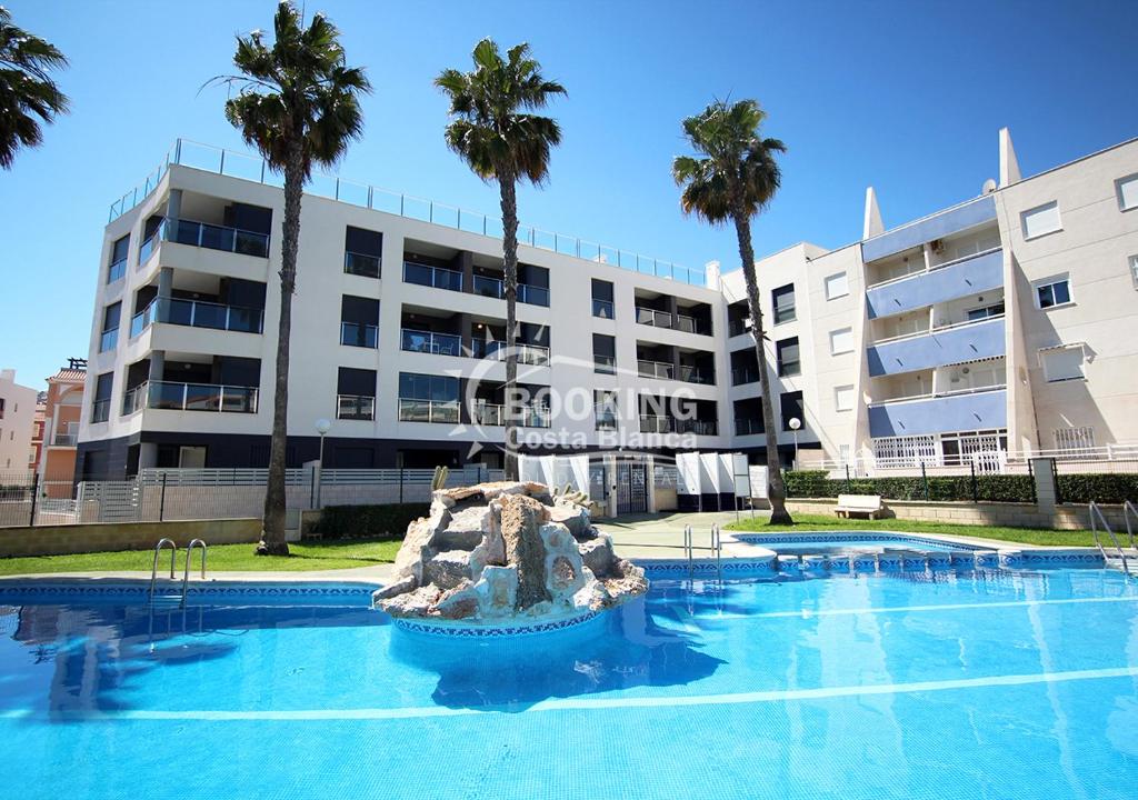 una piscina di fronte a un edificio con palme di AL045 Pinada Beach III La Mata a La Mata