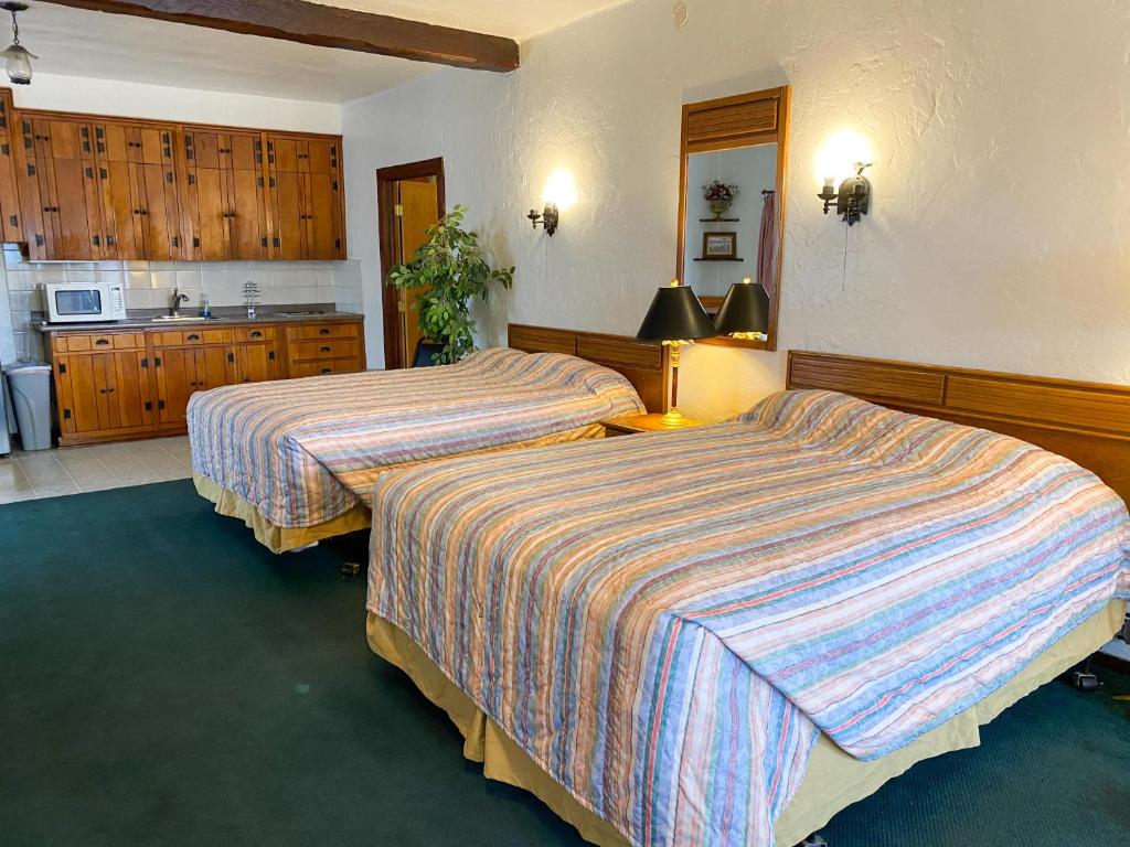 シャイアンにあるGuest Ranch Motelのベッド2台とキッチンが備わるホテルルームです。
