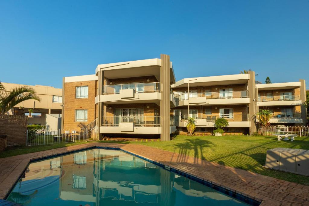 an apartment building with a swimming pool in front of it at Labori Ballito in Ballito