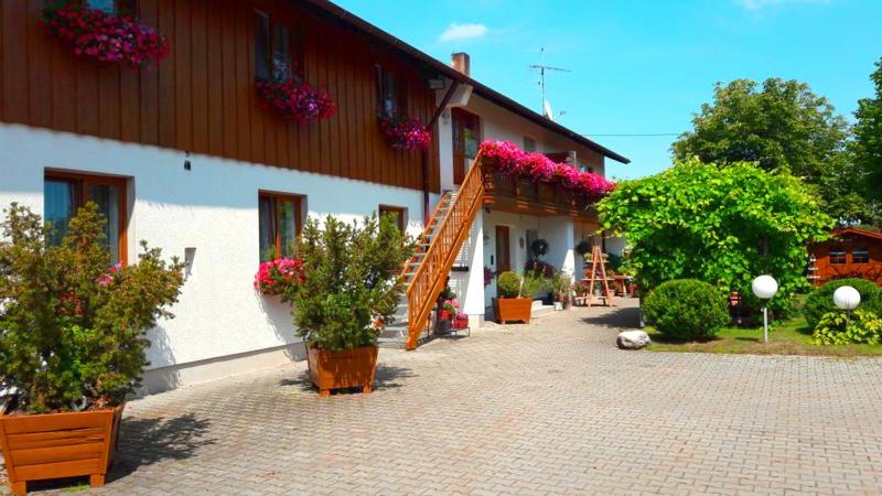 un edificio con macetas al costado. en Pension zum Krug, Messe München, en Hergolding