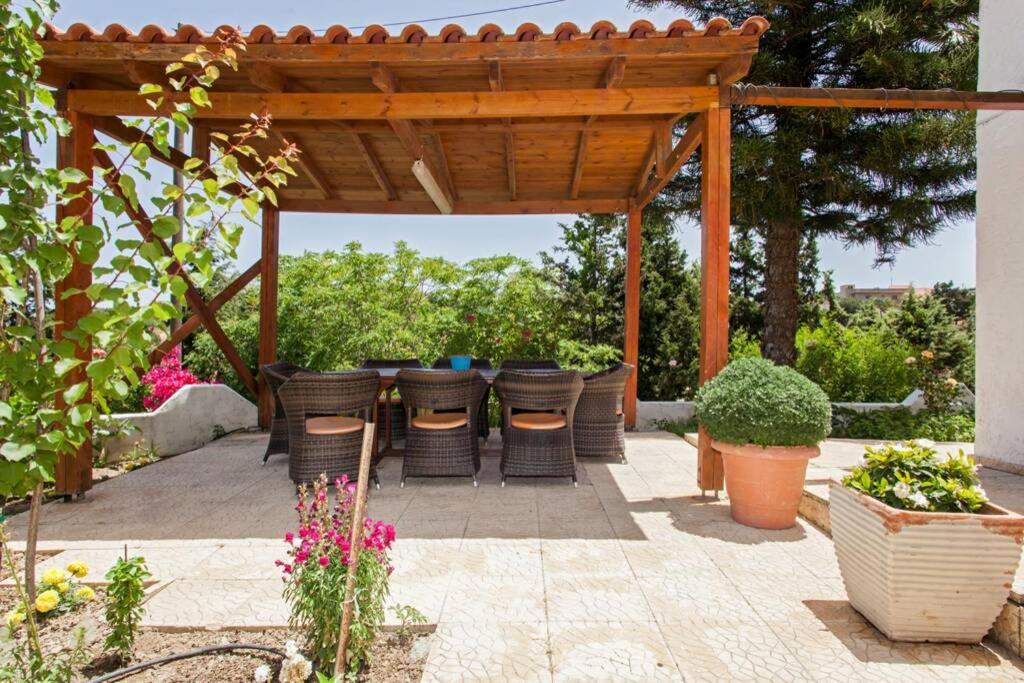 een patio met een pergola met stoelen en planten bij Harmony Country House - Live in the Nature in Kounávoi