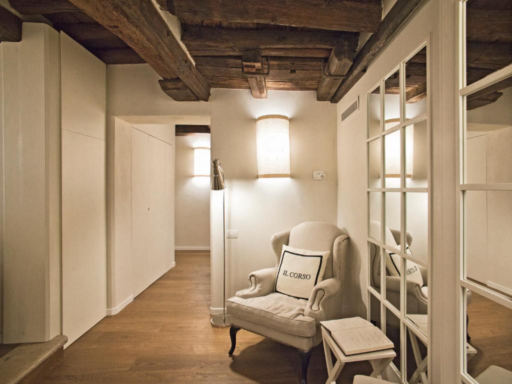 B&B Il Corso في سيينا: غرفة معيشة مع كرسي وطاولة