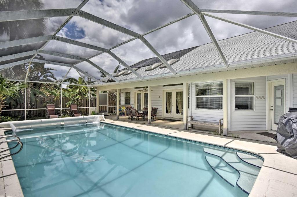 a swimming pool with a pergola on a house at Cocoa Beach Paradise with Indoor and Outdoor Fun! in Merritt Island