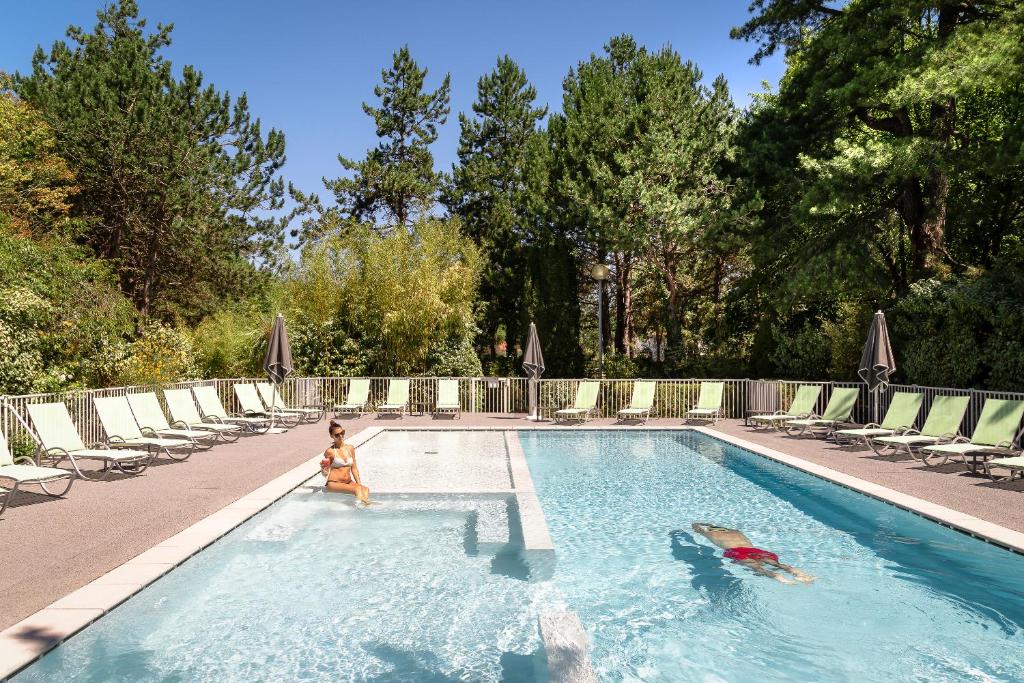 a child is playing in a swimming pool at Hôtel du Parc in Hardelot-Plage