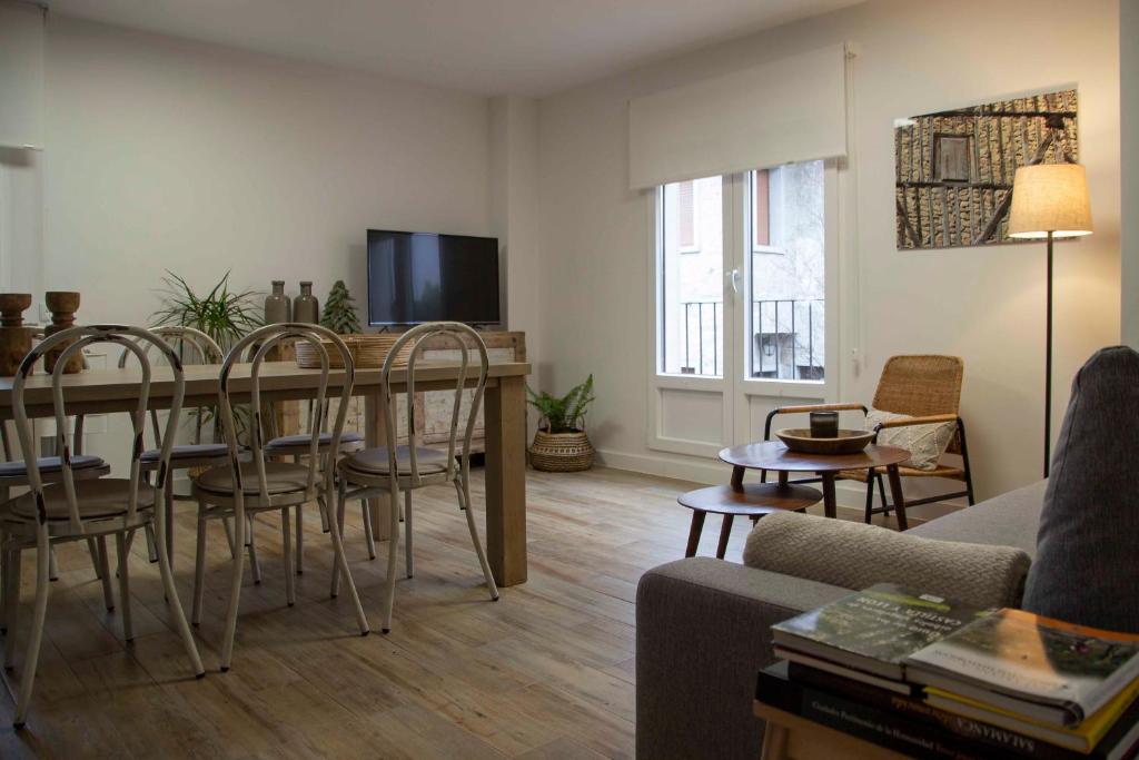 a living room with a table and chairs and a television at Alojamientos Rurality Home in La Alberca